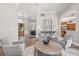Open-concept living area with gray armchairs, a round wood table, and views of the front yard at 685 Mayo Ave, Maitland, FL 32751