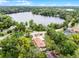 Aerial view of home near a lake with mature trees and well-manicured green lawn at 740 Florida Blvd, Altamonte Springs, FL 32701