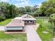 Aerial view of a charming blue home with a porte-cochere, brick driveway, and lush landscaping at 740 Florida Blvd, Altamonte Springs, FL 32701