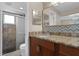 Beautiful bathroom featuring updated vanity with a granite countertop and tiled shower with a glass door at 740 Florida Blvd, Altamonte Springs, FL 32701