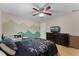 This bedroom has a mural of a mountain range, wood floors and a ceiling fan at 740 Florida Blvd, Altamonte Springs, FL 32701