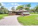 Lovely blue house featuring a porte-cochere, an expansive porch, brick driveway, and a manicured lawn at 740 Florida Blvd, Altamonte Springs, FL 32701
