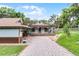 Quaint blue home exterior with a porch swing, covered parking area, and brick-paved driveway at 740 Florida Blvd, Altamonte Springs, FL 32701