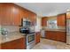 Well-lit kitchen featuring stainless steel appliances, warm wood cabinets, and granite countertops at 740 Florida Blvd, Altamonte Springs, FL 32701