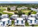 An aerial view showing modern townhomes backing onto a lush golf course and neighborhood landscape at 7740 Sandy Ridge Dr # 114, Reunion, FL 34747