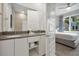 Bright bathroom featuring double sinks, white cabinets, and a view into the adjacent bedroom at 7740 Sandy Ridge Dr # 114, Reunion, FL 34747