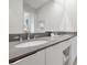 Modern bathroom with double sinks, gray countertops, and ample storage space at 7740 Sandy Ridge Dr # 114, Reunion, FL 34747