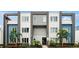 Modern three-story building with gray, white and blue color scheme and decorative palm trees in front at 7740 Sandy Ridge Dr # 114, Reunion, FL 34747