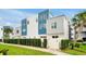 Modern townhouse with blue and white exterior, well-maintained landscaping, and privacy fence at 7740 Sandy Ridge Dr # 114, Reunion, FL 34747