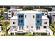 An aerial view highlights modern townhome exteriors with patios and lush landscaping at 7740 Sandy Ridge Dr # 114, Reunion, FL 34747