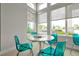 Game room with turquoise translucent chairs near windows that display palm trees and sunshine at 7740 Sandy Ridge Dr # 114, Reunion, FL 34747