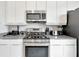Close-up view of the kitchen area showcasing stainless steel appliances and gray countertops at 7740 Sandy Ridge Dr # 114, Reunion, FL 34747