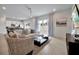Well-lit living room featuring a sofa, patio access, and views into the kitchen at 7740 Sandy Ridge Dr # 114, Reunion, FL 34747