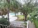 View of the sparkling pool surrounded by lush greenery and a white fence at 7900 S Orange Blossom Trl # 2108, Orlando, FL 32809