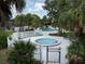 A community pool with hot tub is shown enclosed by white fencing and tropical landscaping at 7900 S Orange Blossom Trl # 2108, Orlando, FL 32809