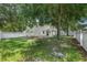 Spacious grassy backyard surrounded by trees and a white fence at 809 Kazaros Cir, Ocoee, FL 34761
