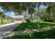 Inviting two-story home with a lush green lawn, mature landscaping, and a brick driveway at 809 Kazaros Cir, Ocoee, FL 34761