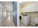 Convenient laundry room with modern washer/dryer, storage cabinets, and utility sink at 809 Kazaros Cir, Ocoee, FL 34761