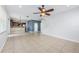 Open-concept living room with ceiling fan, tile floors, and view of the kitchen and staircase at 809 Kazaros Cir, Ocoee, FL 34761