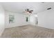 Spacious main bedroom with neutral carpet, ceiling fan and natural light from two windows at 809 Kazaros Cir, Ocoee, FL 34761