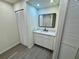 Cozy bathroom featuring a single-sink vanity with storage below and a framed mirror at 8320 Dominguin St, Orlando, FL 32817