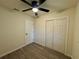 Bedroom with wood-look floors, ceiling fan, and a closet at 8320 Dominguin St, Orlando, FL 32817