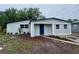 Charming single story home featuring a blue door, fresh exterior paint and landscaping at 8320 Dominguin St, Orlando, FL 32817