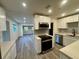 Open concept kitchen and living space featuring stainless appliances and modern finishes at 8320 Dominguin St, Orlando, FL 32817