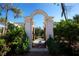 Stone archway leading to a garden walkway with lush greenery and colorful flowers at 835 Antonette Ave, Winter Park, FL 32789
