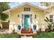 Inviting front entrance with a bright blue door, brick steps, and decorative potted plants on each side at 835 Antonette Ave, Winter Park, FL 32789