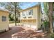 Charming two-story home with three-car garage, brick driveway, and light yellow stucco exterior at 835 Antonette Ave, Winter Park, FL 32789