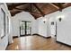 Living room featuring hardwood floors, beamed ceiling and doors leading to outside deck at 835 Antonette Ave, Winter Park, FL 32789
