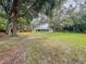 Large backyard with mature trees and partial fencing provides privacy and a beautiful outdoor space at 8404 Singapore Ct, Orlando, FL 32817