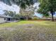 Expansive backyard featuring a screened lanai, picnic table, and mature trees providing ample shade at 8404 Singapore Ct, Orlando, FL 32817