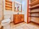 Bathroom featuring a wooden vanity, tile floors, and adjacent built-in shelving at 8404 Singapore Ct, Orlando, FL 32817
