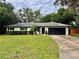 Inviting single-story home with a lush green lawn, mature trees, and a convenient attached two-car garage at 8404 Singapore Ct, Orlando, FL 32817