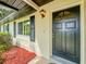 Elegant front door with a decorative window, set against a landscaped exterior with tasteful accents at 8404 Singapore Ct, Orlando, FL 32817