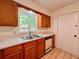 Clean kitchen with wooden cabinets, tile flooring and a stainless steel sink at 8404 Singapore Ct, Orlando, FL 32817