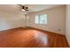 Spacious living room features wood floors, a ceiling fan and a large window at 8404 Singapore Ct, Orlando, FL 32817