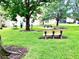 Inviting common area features mature trees, lush green grass, benches and picnic table for outdoor enjoyment at 9918 Turf Way # 5, Orlando, FL 32837