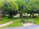 Landscaped common area with mature shade trees, sidewalks, and a bike rack for residents' convenience at 9918 Turf Way # 5, Orlando, FL 32837