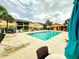 Beautiful community pool with lounge chairs, palm trees, and a cabana, perfect for summer relaxation at 9918 Turf Way # 5, Orlando, FL 32837