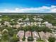 Expansive aerial shot of the neighborhood, showcasing a single-Gathering home with a screened-in pool in a lush, green landscape at 12641 Arley Dr, Windermere, FL 34786