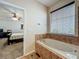 Bright bathroom featuring a soaking tub with tile surround and a window with blinds at 12641 Arley Dr, Windermere, FL 34786