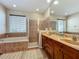 Well lit bathroom featuring a soaking tub, walk-in shower with glass door, and double sink vanity at 12641 Arley Dr, Windermere, FL 34786