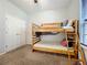 This bedroom is perfect for children, featuring a window, closet, and a bunk bed with a wooden frame at 12641 Arley Dr, Windermere, FL 34786