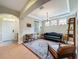 Cozy living room with a tufted leather couch, decorative rug, and ample natural light at 12641 Arley Dr, Windermere, FL 34786