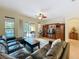 Spacious living area with a dark leather sofa, media center, and views of the outdoor pool and patio at 12641 Arley Dr, Windermere, FL 34786