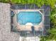 Aerial view of a private screened-in pool showcasing a spacious deck area and lush surrounding foliage for ultimate relaxation at 12641 Arley Dr, Windermere, FL 34786
