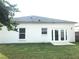 Rear exterior view of the home features a lawn, windows, and glass pane doors at 10513 Leader Ln, Orlando, FL 32825